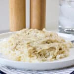 Side view of one serving of Chicken Gravy Over Rice on a white plate.