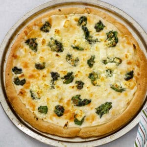 Feature image of an overhead shot of the baked pizza before being cut.