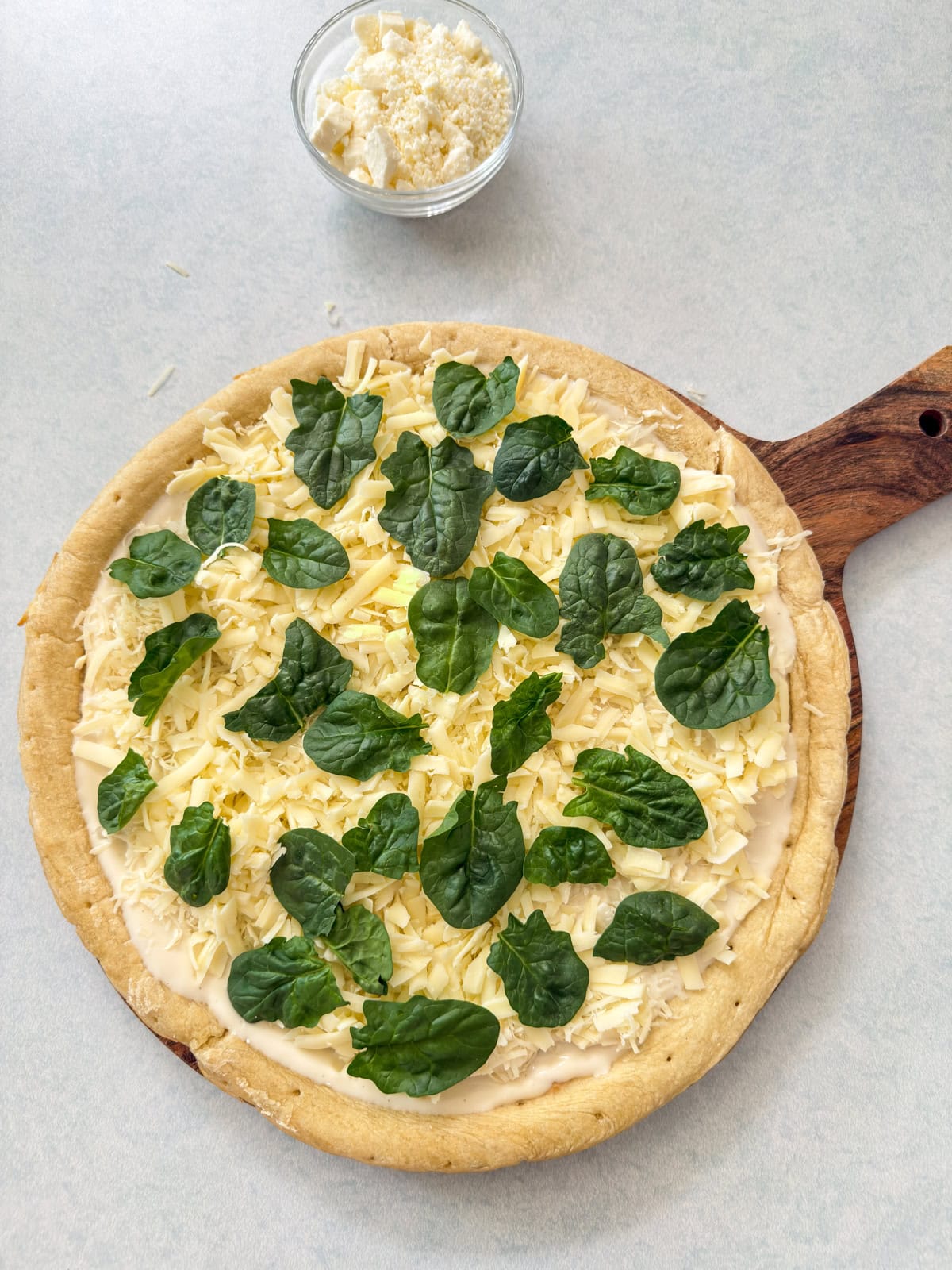 The provolone, parmesan, and asiago cheese added and the spinach on top of that.