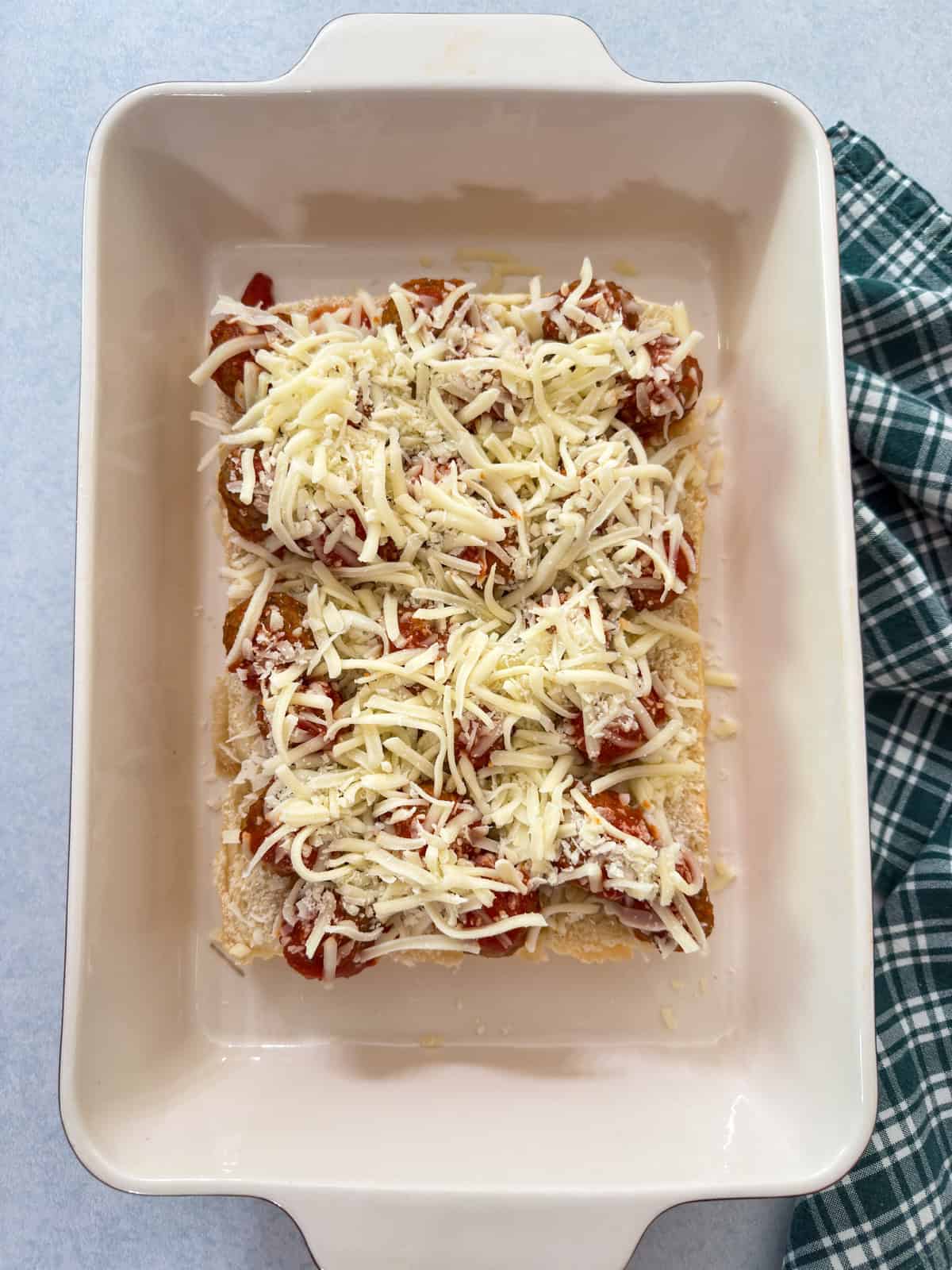 The bottom of the rolls with meatballs, sauce and cheese added.