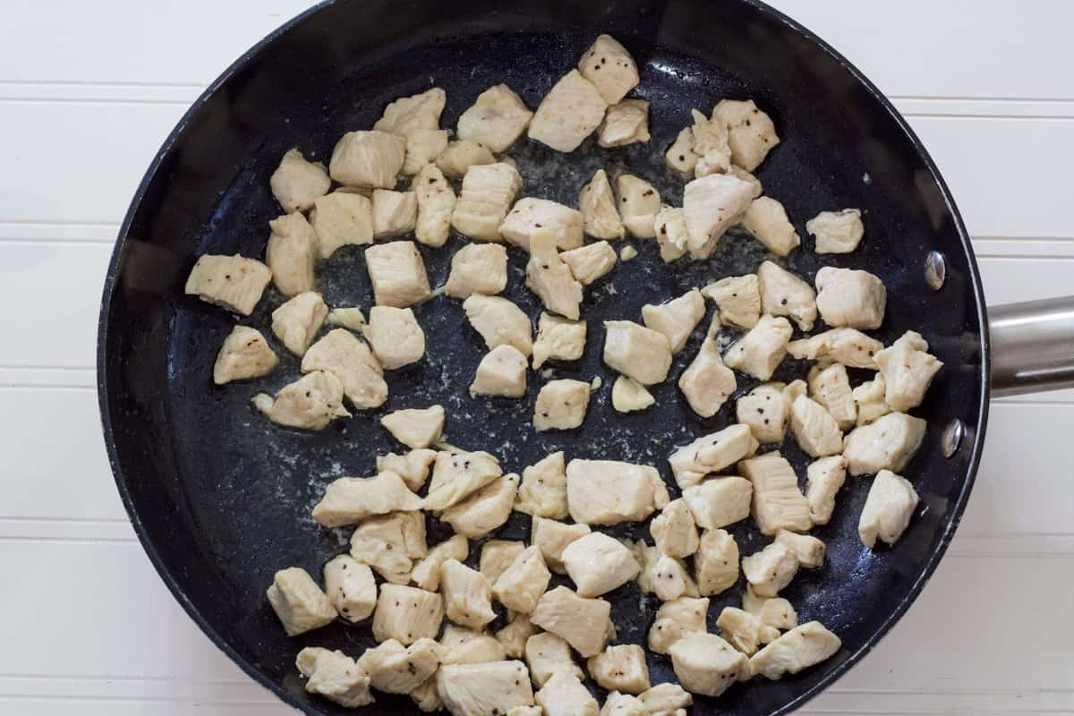 The cooked chicken chunks in a skillet.