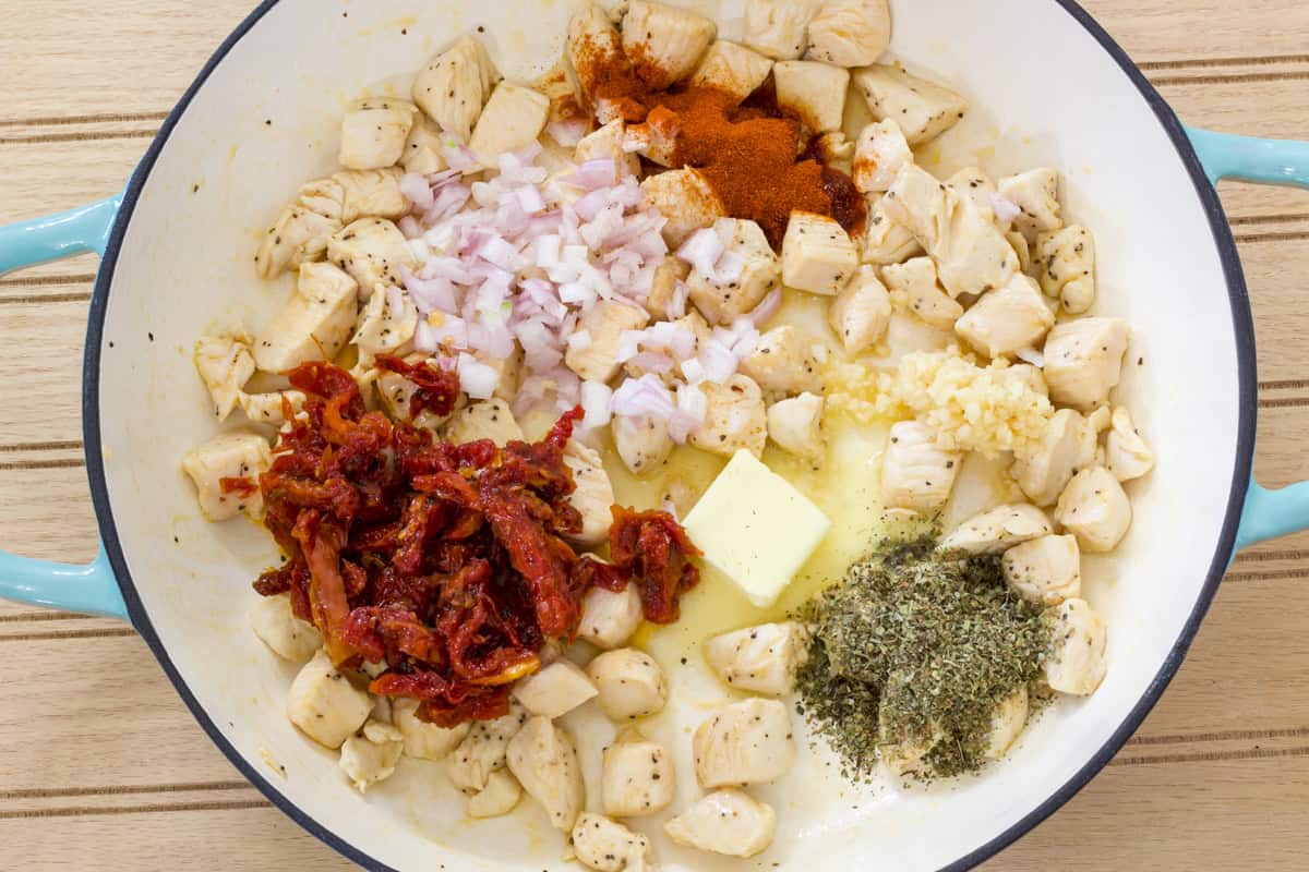 The chicken in the skillet with the butter, shallots, sun-dried tomatoes, garlic, Italian seasoning and paprika added.