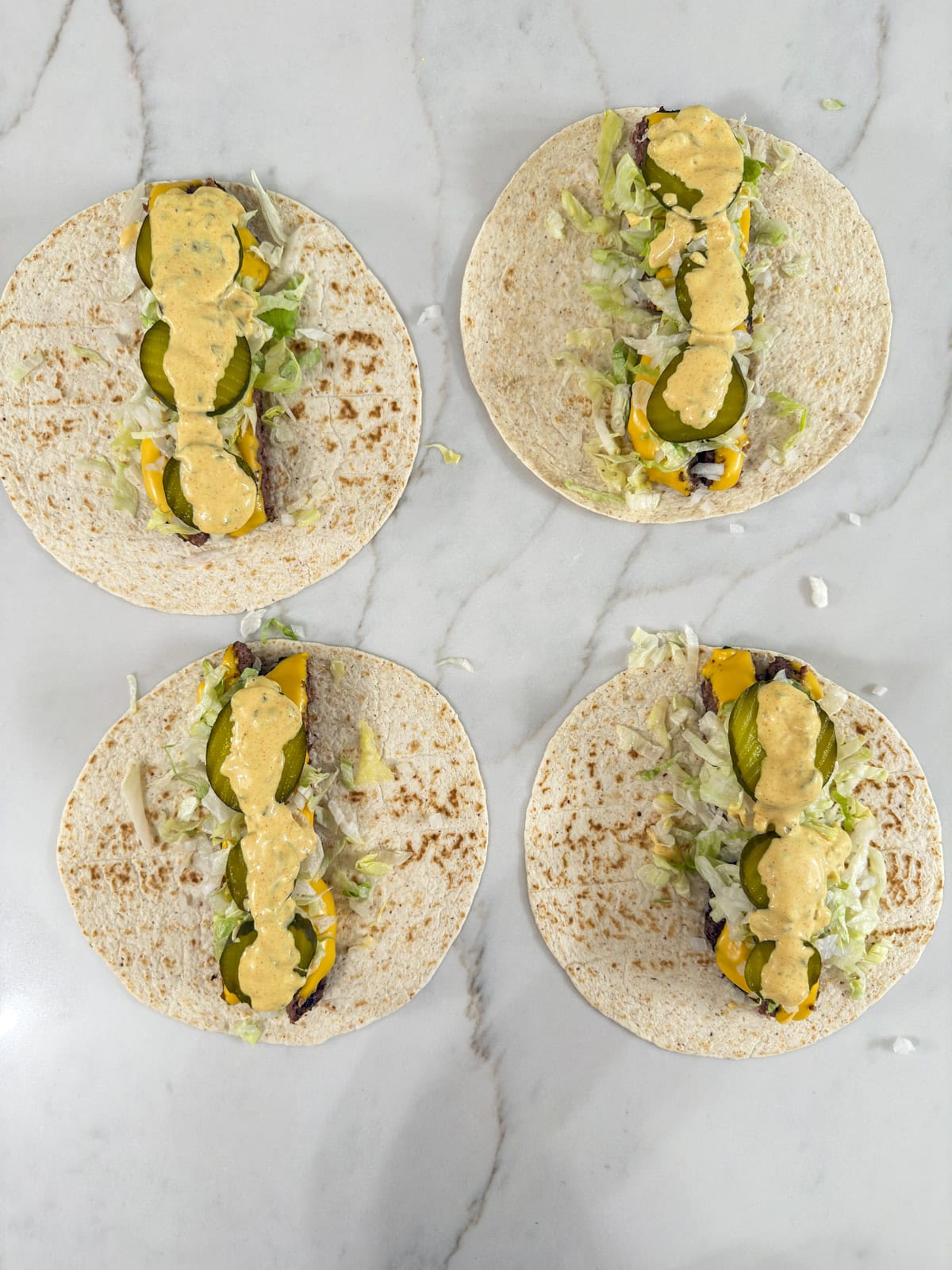 The lettuce, onions, pickles and big mac sauce on the beef, all on the tortilla.