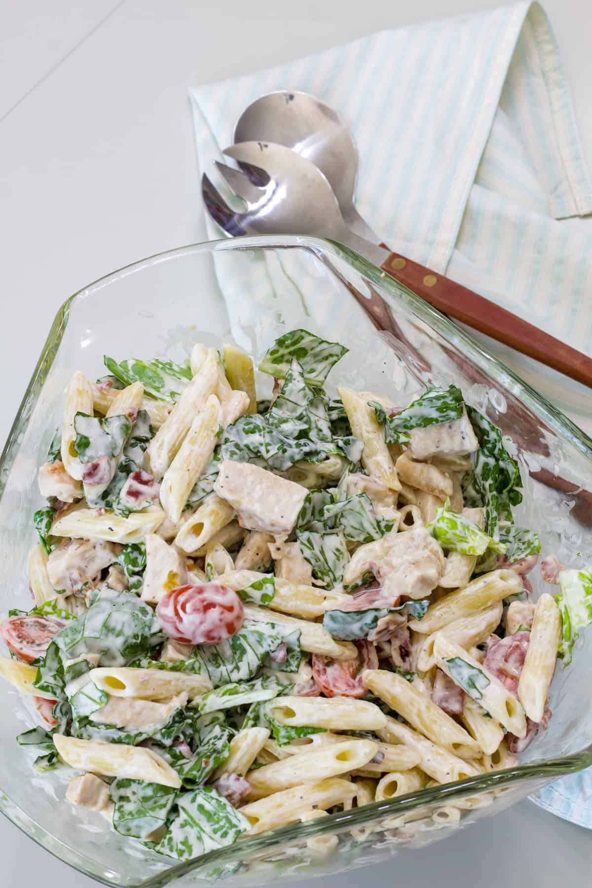 A large glass serving bowl filled with Chicken BLT Pasta Salad.