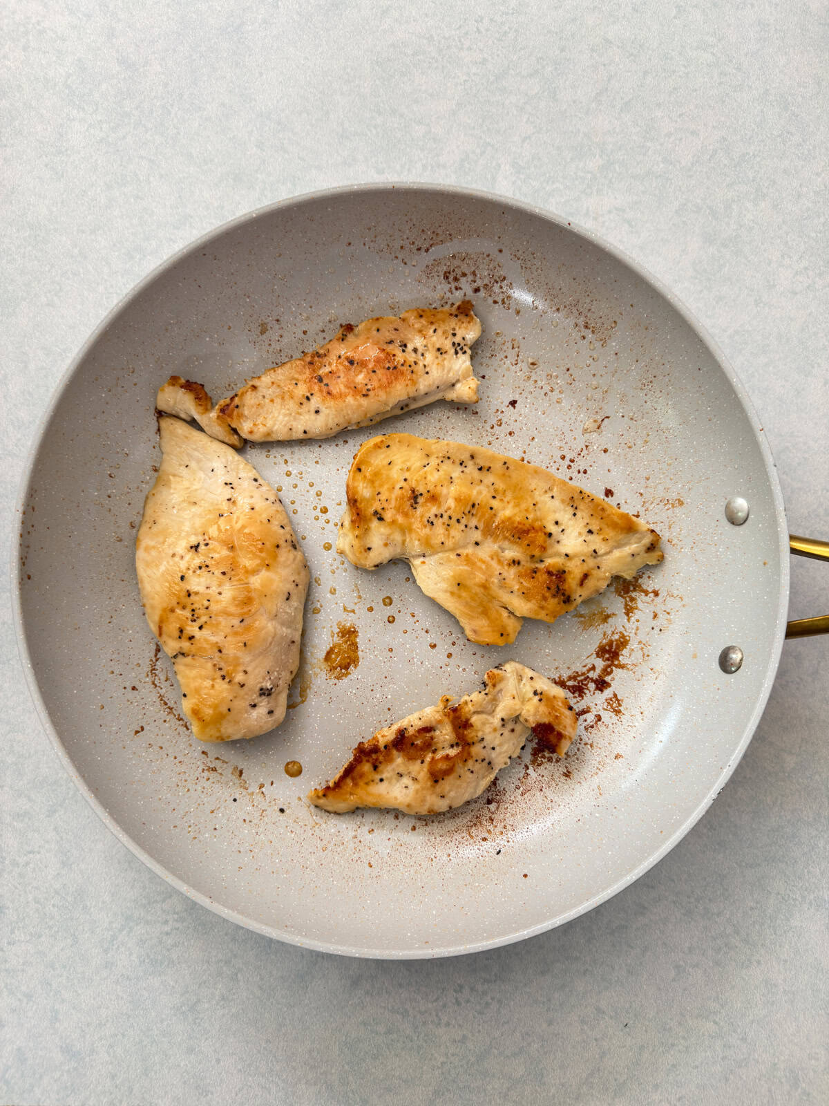 The chicken in a skillet after it's been cooked.
