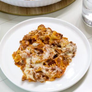 Feature image of one serving of lasagna on a white plate.