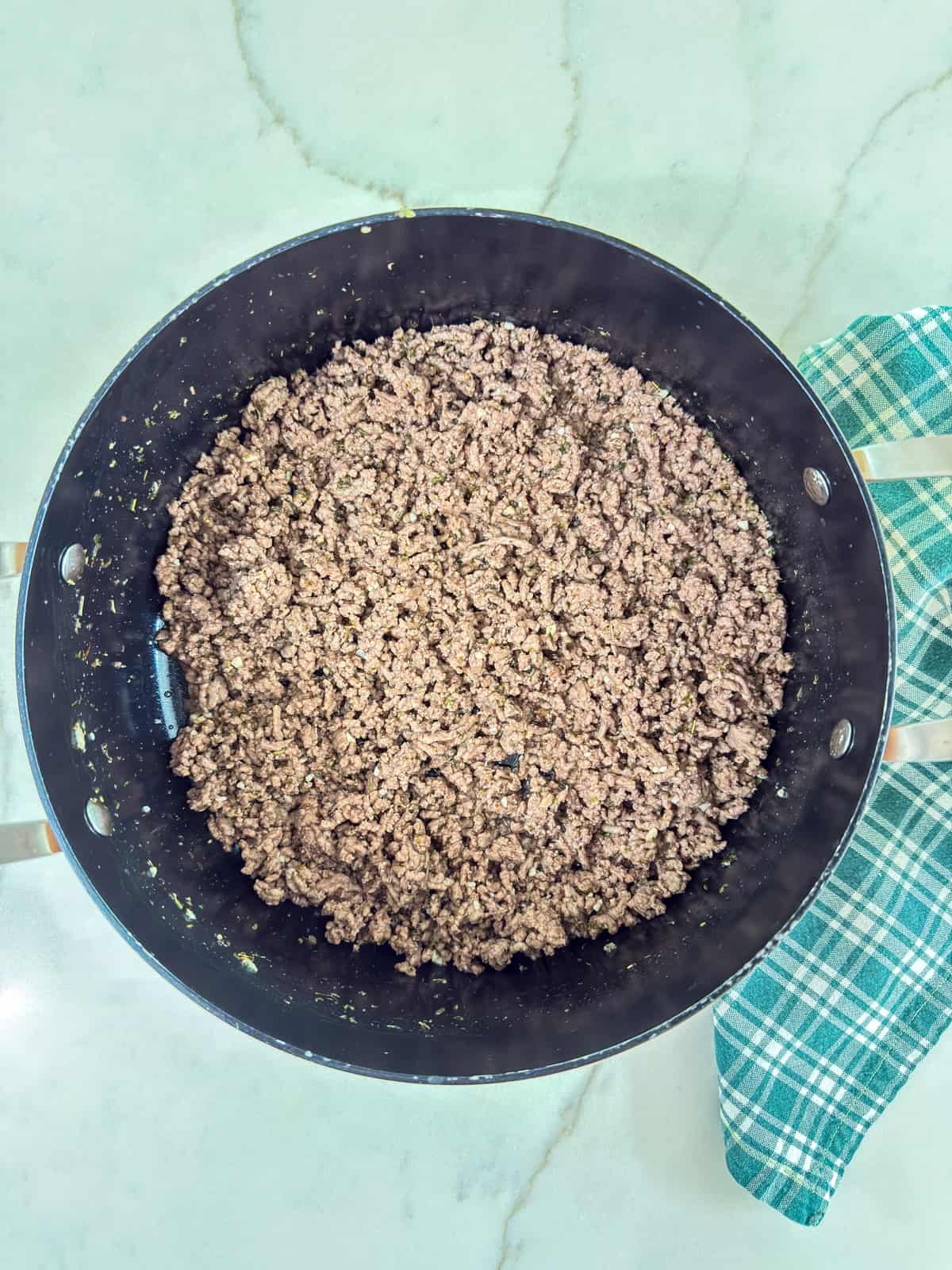 A pan filled with ground beef on a counter