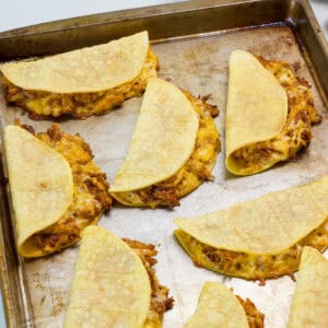 Feature image of the baked tacos still on the rimmed baking sheet.