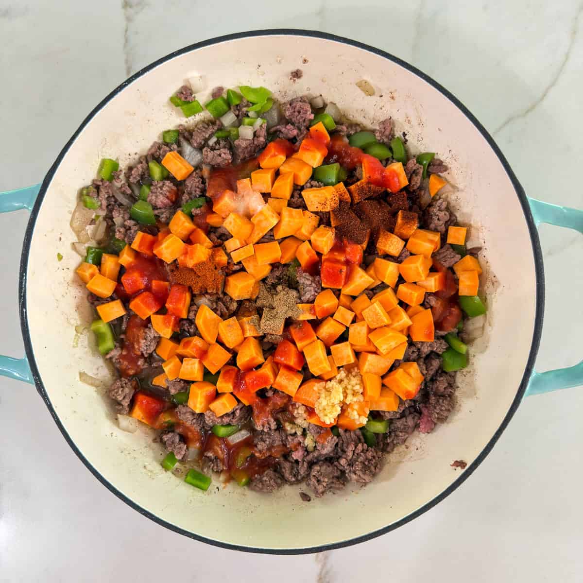 The skillet with the sweet potatoes, tomato sauce, broth and spices added.