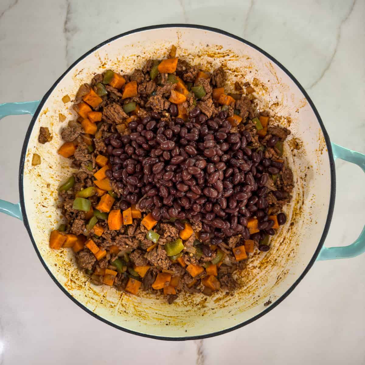 The dish in the skillet with the beans in a pile on top.